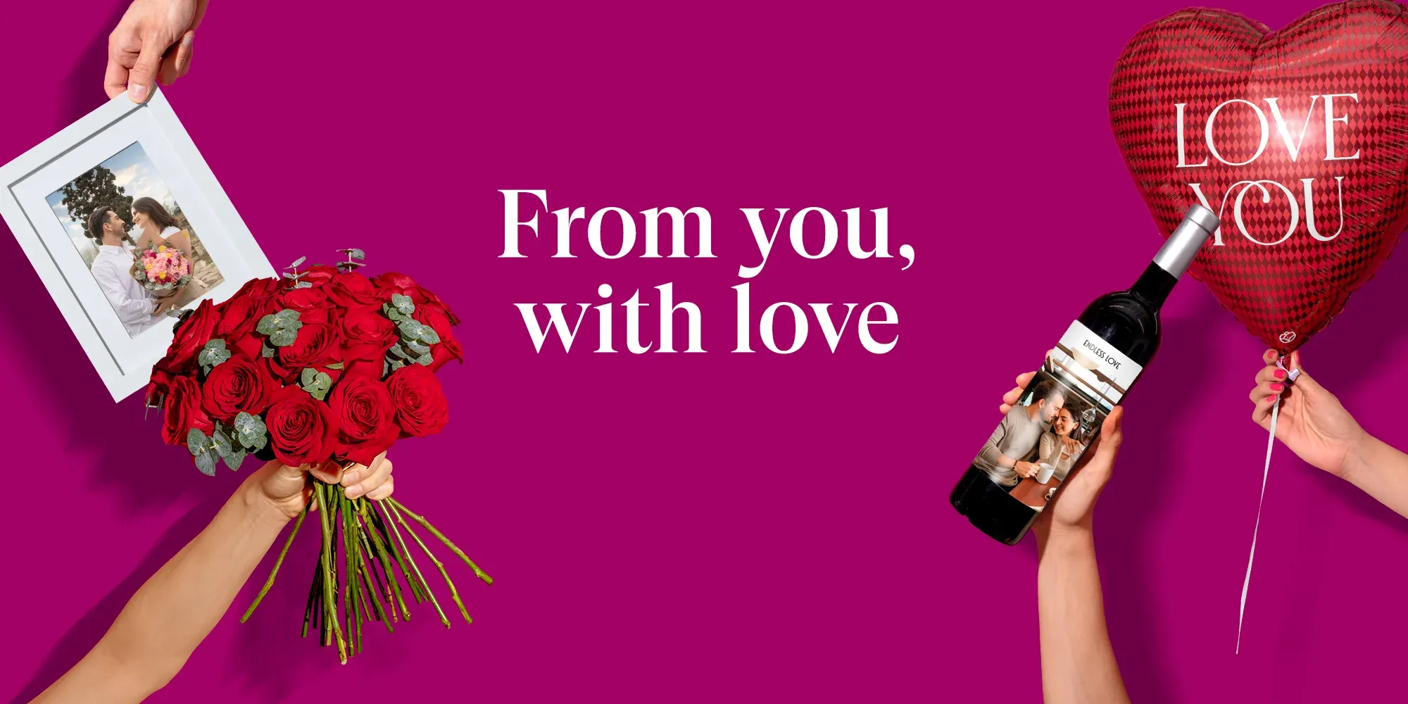 Banner bouquet of red roses, a “LOVE YOU” balloon, and a personalized wine bottle with photo, against a pink fuchsia background with the text “From you, with love” – Enviaflores.